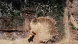 Escavatore al lavoro vicino a una strada di trasporto nella cava di bauxite