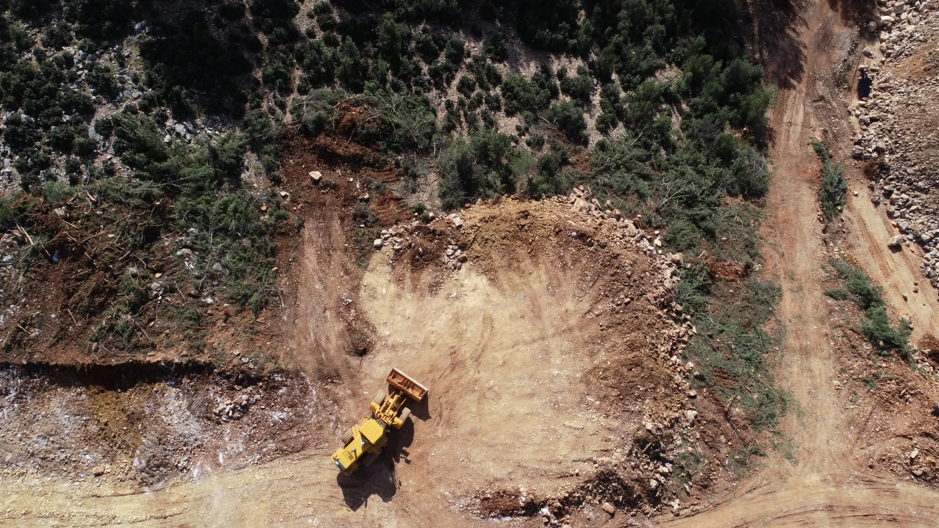Escavatore al lavoro vicino a una strada di trasporto nella cava di bauxite