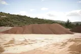 Cumuli separati di bauxite in un piazzale di carico all’aperto