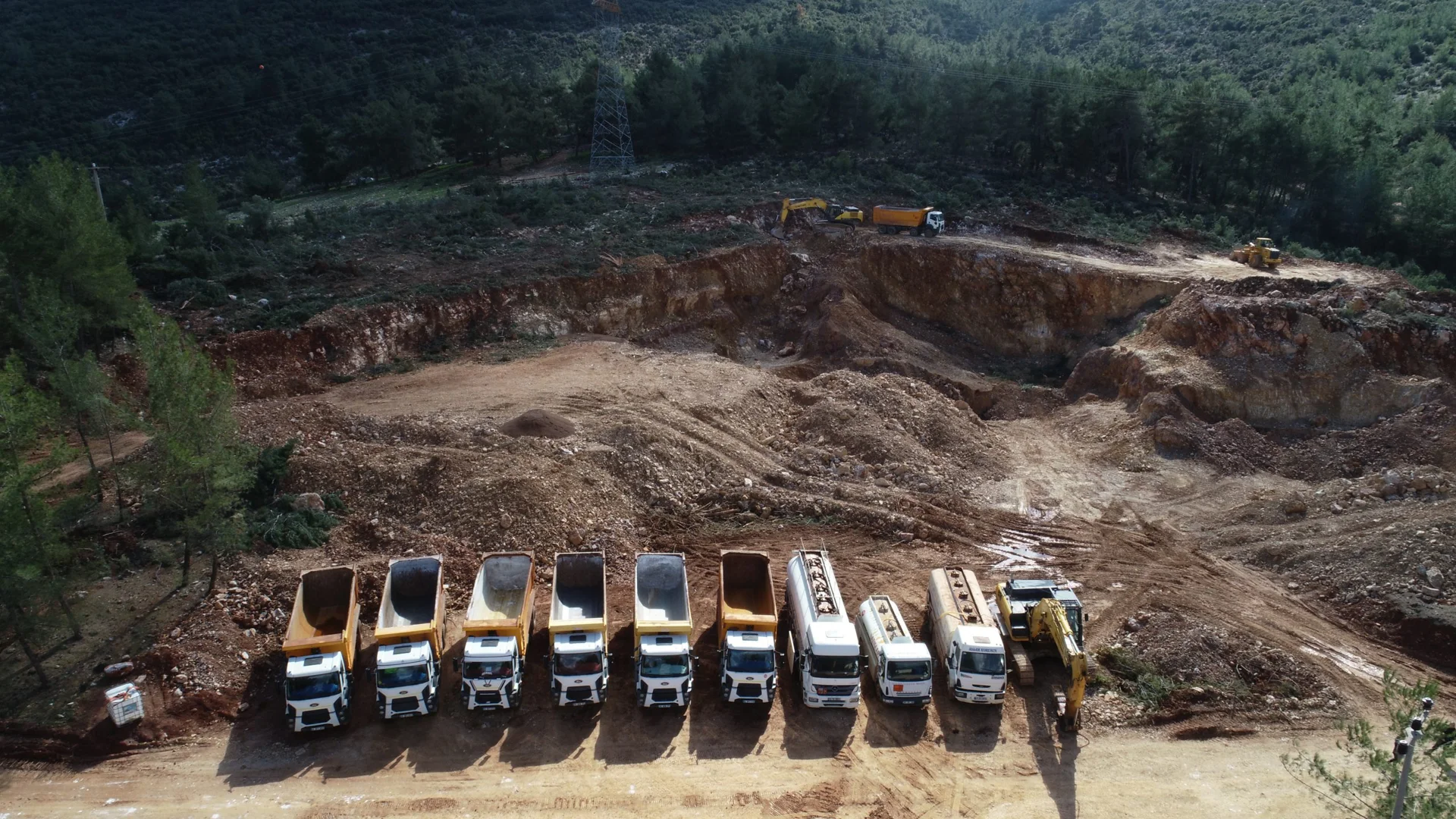 Aerial view of a bauxite quarry in Türkiye with haulage trucks and excavation equipment